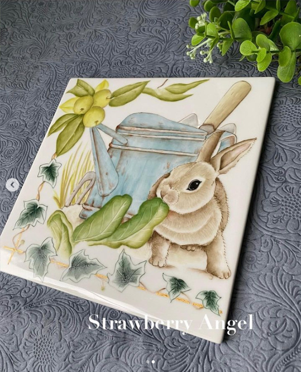 うさぎやじょうろが描かれた陶板を斜めから見たところ